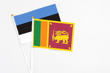 Sri Lanka and Estonia stick flags on white background. High quality fabric, miniature national flag. Peaceful global concept.White floor for copy space.