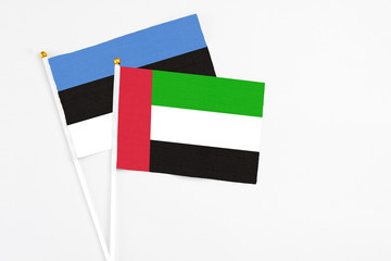 United Arab Emirates and Estonia stick flags on white background. High quality fabric, miniature national flag. Peaceful global concept.White floor for copy space.
