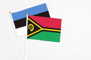 Vanuatu and Estonia stick flags on white background. High quality fabric, miniature national flag. Peaceful global concept.White floor for copy space.