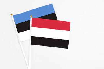 Yemen and Estonia stick flags on white background. High quality fabric, miniature national flag. Peaceful global concept.White floor for copy space.