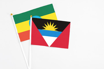 Antigua and Barbuda and Ethiopia stick flags on white background. High quality fabric, miniature national flag. Peaceful global concept.White floor for copy space.