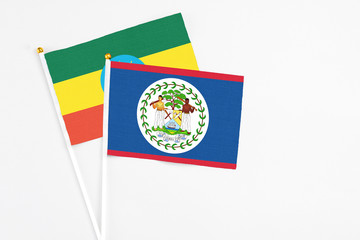 Belize and Ethiopia stick flags on white background. High quality fabric, miniature national flag. Peaceful global concept.White floor for copy space.