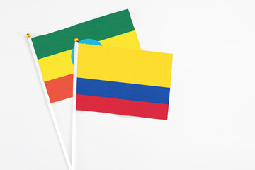 Colombia and Ethiopia stick flags on white background. High quality fabric, miniature national flag. Peaceful global concept.White floor for copy space.