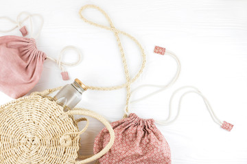 Fashion round straw bag and eco bags. Flat lay, top view. Zero waste concept.