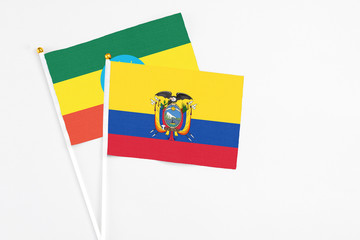 Ecuador and Ethiopia stick flags on white background. High quality fabric, miniature national flag. Peaceful global concept.White floor for copy space.