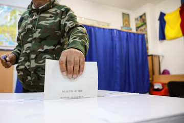 Shallow depth of field (selective focus) image with a man casting his ballot in the first round of a presidential election, in Bucharest, Romania