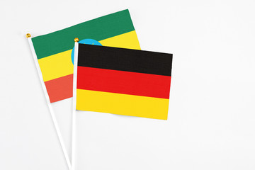 Germany and Ethiopia stick flags on white background. High quality fabric, miniature national flag. Peaceful global concept.White floor for copy space.