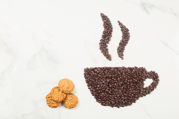 Coffee cup with steam made from roasted coffee beans or grain isolated on white marble background. Coffee shop concept