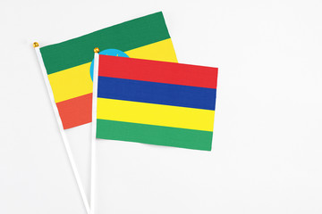 Mauritius and Ethiopia stick flags on white background. High quality fabric, miniature national flag. Peaceful global concept.White floor for copy space.