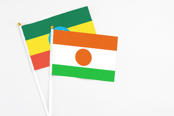 Niger and Ethiopia stick flags on white background. High quality fabric, miniature national flag. Peaceful global concept.White floor for copy space.