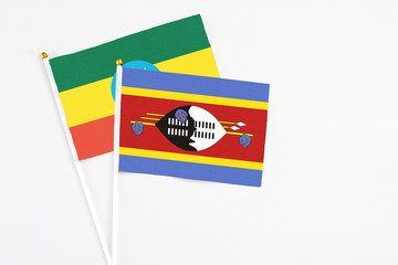 Swaziland and Ethiopia stick flags on white background. High quality fabric, miniature national flag. Peaceful global concept.White floor for copy space.
