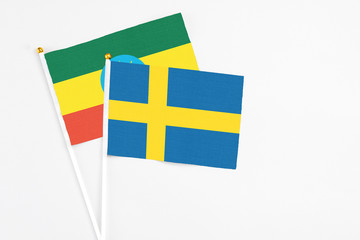 Sweden and Ethiopia stick flags on white background. High quality fabric, miniature national flag. Peaceful global concept.White floor for copy space.