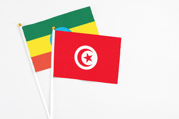 Tunisia and Ethiopia stick flags on white background. High quality fabric, miniature national flag. Peaceful global concept.White floor for copy space.