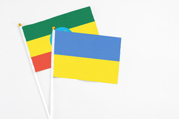 Ukraine and Ethiopia stick flags on white background. High quality fabric, miniature national flag. Peaceful global concept.White floor for copy space.