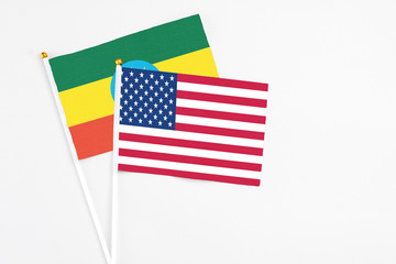 United States and Ethiopia stick flags on white background. High quality fabric, miniature national flag. Peaceful global concept.White floor for copy space.