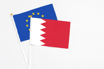 Bahrain and European Union stick flags on white background. High quality fabric, miniature national flag. Peaceful global concept.White floor for copy space.