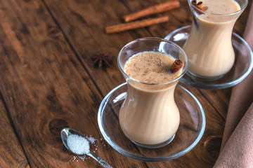 Indian masala tea with spices on a wooden background