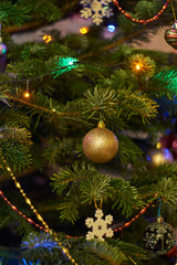 New Year's composition, Christmas decorations. Christmas toys hanging on a fir-tree against the background of a luminous Christmas garland