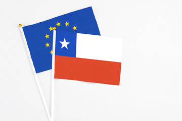 Chile and European Union stick flags on white background. High quality fabric, miniature national flag. Peaceful global concept.White floor for copy space.