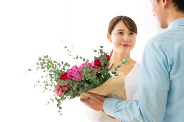 花束を贈る夫と笑顔の妻