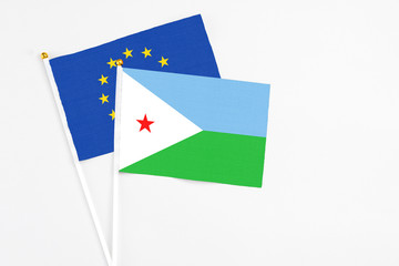 Djibouti and European Union stick flags on white background. High quality fabric, miniature national flag. Peaceful global concept.White floor for copy space.