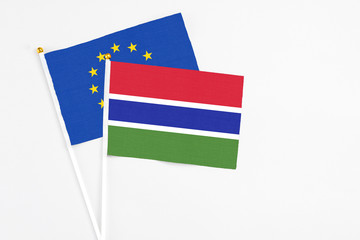 Gambia and European Union stick flags on white background. High quality fabric, miniature national flag. Peaceful global concept.White floor for copy space.