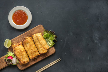 fried vegetable spring rolls with fresh ingredients served and sour sauce in an oriental restaurant