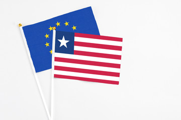 Liberia and European Union stick flags on white background. High quality fabric, miniature national flag. Peaceful global concept.White floor for copy space.