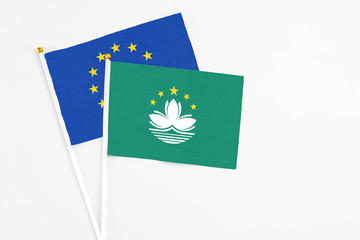 Macao and European Union stick flags on white background. High quality fabric, miniature national flag. Peaceful global concept.White floor for copy space.