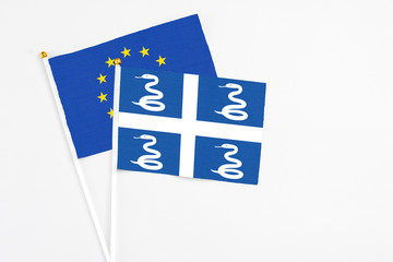Martinique and European Union stick flags on white background. High quality fabric, miniature national flag. Peaceful global concept.White floor for copy space.