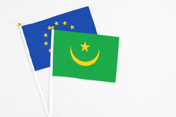 Mauritania and European Union stick flags on white background. High quality fabric, miniature national flag. Peaceful global concept.White floor for copy space.