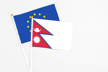 Nepal and European Union stick flags on white background. High quality fabric, miniature national flag. Peaceful global concept.White floor for copy space.