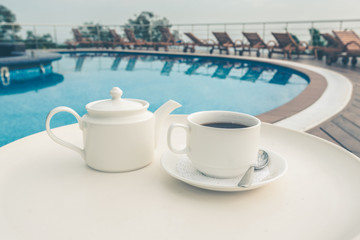 Fototapeta na wymiar cup on the table near the pool . White ceramic coffee cup
