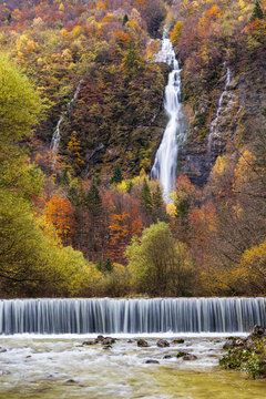 Waterfall in a colorful autumn forest in italy