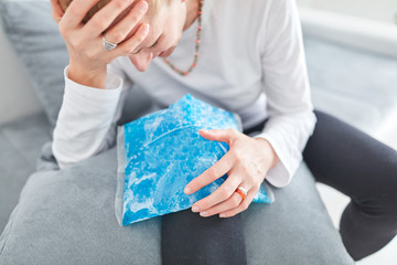 Injured woman holding ice pack / bag for cooling down the knee pain.