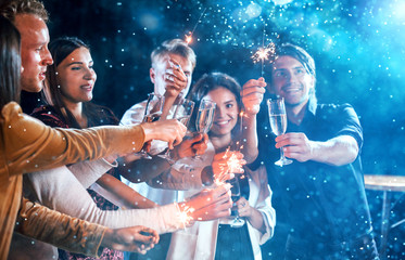 Group of cheerful young people have party and celebrating new year indoors