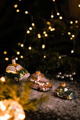 Christmas tree ornaments, tiny car on snowy table under the fir tree and bokeh lights with white candle in the background. Beautiful mysterious village decoration, greeting card, new year celebration 