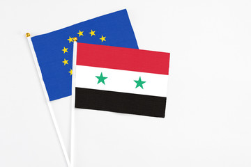 Syria and European Union stick flags on white background. High quality fabric, miniature national flag. Peaceful global concept.White floor for copy space.