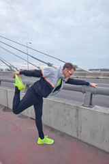 Sportsman working out / jogging on a big city urban bridge.