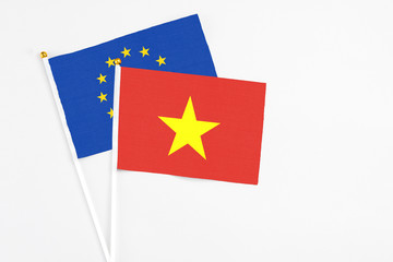 Vietnam and European Union stick flags on white background. High quality fabric, miniature national flag. Peaceful global concept.White floor for copy space.