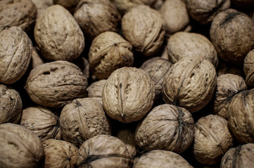Walnuts background. Texture walnuts in dark tinted. Top view, selective focus, camera noise