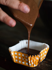 Motion blur processing homemade chocolate cupcakes on table.