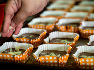 Obraz premium Motion blur spreading almonds sliced on homemade chocolate cupcakes on table.