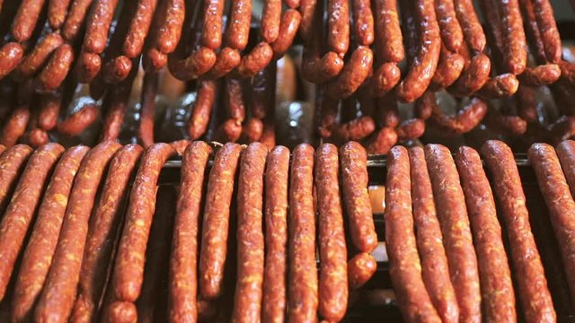 Hunting sausages close - up which is suspended on the shelves, dries in the storage room. Panorama of the sausage which is suspended on laces in the refrigerator.