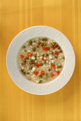 Rice soup with chicken, green peas and carrots. Directly Above.