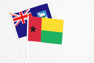 Guinea Bissau and Falkland Islands stick flags on white background. High quality fabric, miniature...