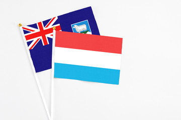 Luxembourg and Falkland Islands stick flags on white background. High quality fabric, miniature national flag. Peaceful global concept.White floor for copy space.