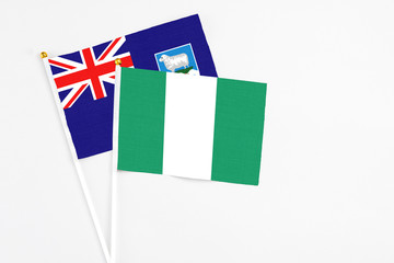 Nigeria and Falkland Islands stick flags on white background. High quality fabric, miniature national flag. Peaceful global concept.White floor for copy space.