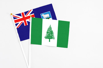 Norfolk Island and Falkland Islands stick flags on white background. High quality fabric, miniature national flag. Peaceful global concept.White floor for copy space.