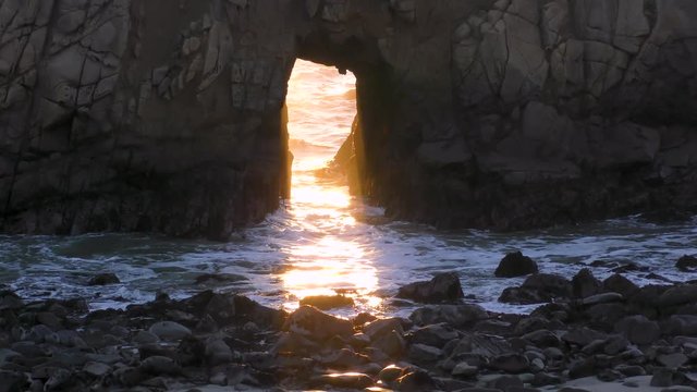 Sunshine glistened through the arch keyhole rock at Pfeiffer beach at Big Bur coastal beach